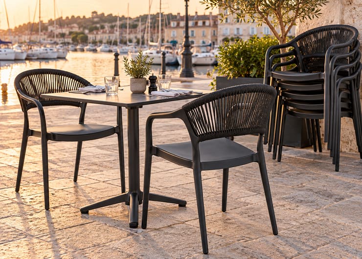 Chaises de terrasse empilables en polypropylène à accoudoirs sur une terrasse de café
